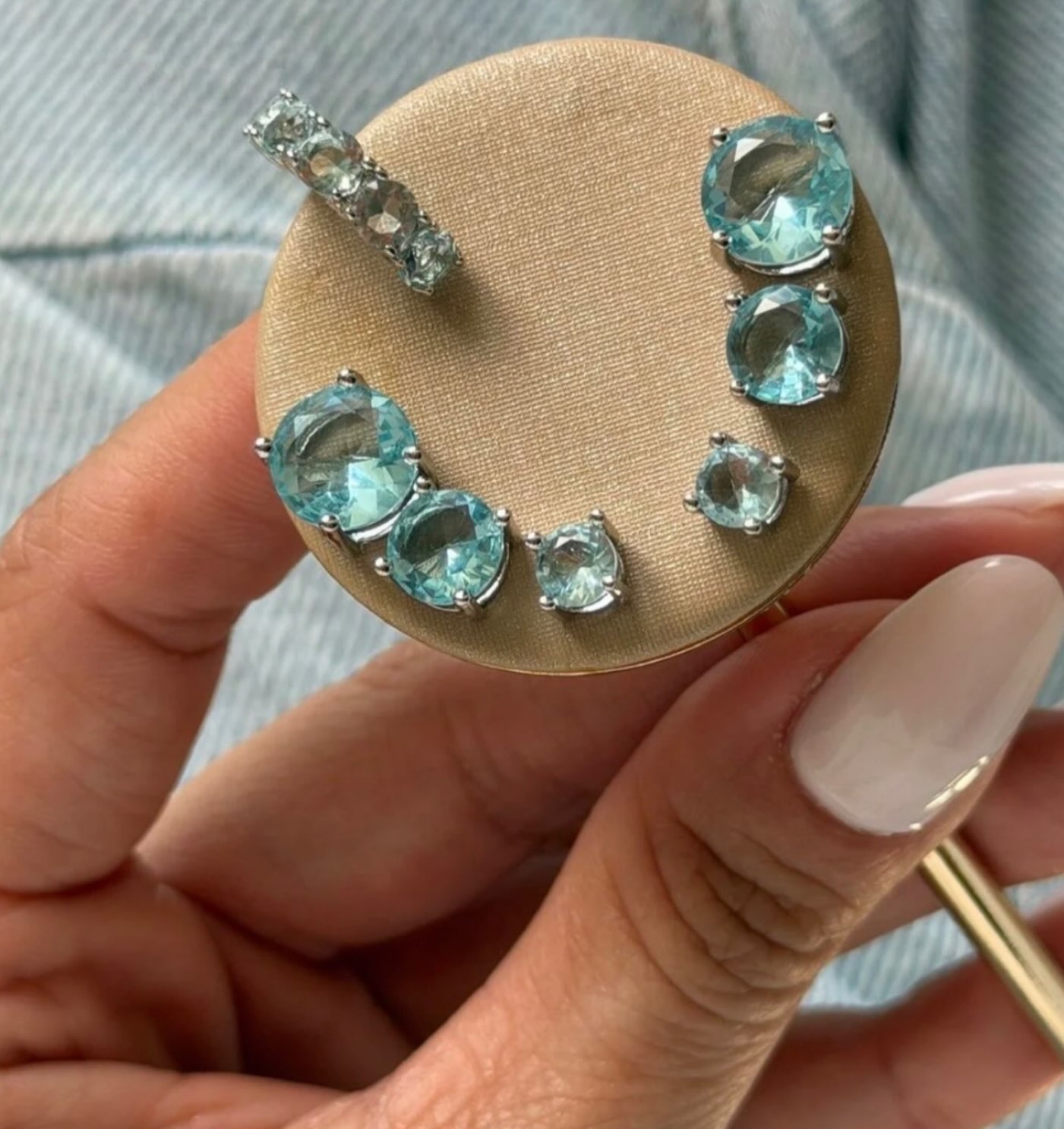 Brincos Calulli com pedras aquamarine em display dourado